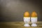 Eggcup and boiled eggs, on wooden table.