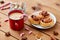 Eggnog with candy cane in cup and cinnamon buns