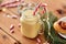 Eggnog with candy cane in mug and cinnamon buns