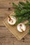 Eggnog cocktail in two glasses arranged with christmas decoration on old wooden table. Evergreen fer tree branch, artificial snow