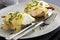 Eggs Benedict dish consisting of poached eggs and sliced ham on toasted muffins