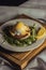 Eggs benedict and poached hollandaise sauce with arugula and lemon. Delicious food for breakfast.