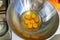 Eggs broken into a metal bowl with unbroken yolks