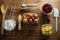 Eggs, butter cubes, cherries, sieve and whisk on a wooden table