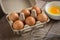 Eggs in carton box and yolk in bowl