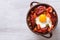 Eggs with chorizo, potatoes and tomatoes in a pot. top view