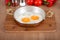 Eggs cooked in oil in a copper pan from a close angle