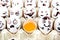 Eggs with drawn cartoon faces and one broken egg in tray.