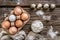 Eggs, flour and quail eggs. Ingredients for cooking. Wooden table. Top view