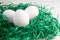 Eggs in a green paper nest. Three white eggs