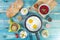 Eggs in Pan with Bread and Hummus and Labneh with Cup of Tea with Limon. On Blue Wood Surface, Perfect Breakfast Meal, Fried eggs