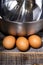 Eggs, whisk and bowl on wooden table