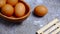 Eggs in a wooden bowl on a table that is neatly and simply arranged which gives an elegant and exclusive impression