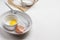 Eggshell, egg and whisk in bowl. Egg yolk in bowl. Flour and sieve on paper