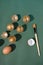 Eggshells painted inside with gold paint with a brush next to it on a dark green background. Flat lay creative Easter arrangement.