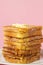 Eggy bread on a pink background. Butter melts on a stack of eggy breads.