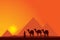 Egypt Great Pyramids with Camel caravan on sunset background