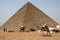Egyptian camel and horse riders circle the base of the Pyramid of Khufu in Cairo in Egypt.