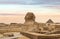 Egyptian Great Sphinx full body portrait with head, feet with all pyramids of Menkaure, Khafre, Khufu in background on a clear,