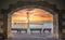 The Egyptian lighthouse at the old harbor of Rethimno through a frame of an arched door, Crete.