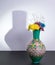 Egyptian traditional pottery vase and three flowers with harsh shadow