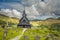 Eidsborg medieval wooden Stave Church and graveyard in front with green forest and cloud sky in the backround, Tokke, Telemark