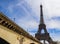 Eiffel Tower against blue sky with clouds and a bridge over Seine River. Paris France. April 2019