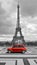 Eiffel tower with car. Black and white photo with red element.