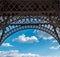Eiffel tower closeup arch frame over blue cloudy sky in Paris France