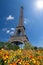 Eiffel tower in the landscape in Paris from the Champ de Mars with a colorful garden and flowers in the foreground