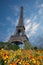 Eiffel tower in the landscape in Paris from the Champ de Mars with a colorful garden and flowers in the foreground