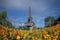 Eiffel tower in the landscape in Paris from the Champ de Mars with a colorful garden and flowers in the foreground