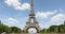 Eiffel Tower in Paris and green field of Mars meadow, people and tourists in a sunny summer day