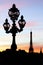 Eiffel tower and Pont Alexandre III bridge lamp posts silhouettes during a Parisian sunset