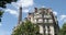 Eiffel Tower top and typical building in Paris with balcony in a sunny day, clear blue sky