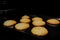 Eight baked crunchy oatmeal cookies on metal sheet in oven