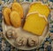 Eight bakery items on a white plate with a patterned background