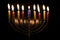 Eight lit Hanukkah candles on black background