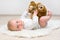 eight month old baby lying on the floor and playing with brown teddy bear, mother's day concept