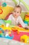 Eight months old baby girl playing with colorful toys