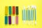 Eight multi-colored pieces of plasticine and eight stacks for working with clay on a bright yellow background