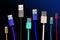 Eight multicolored usb cables are located vertically, on a dark, gloomy isolated background. The family unites. future technologie