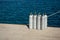 Eight scuba tanks standing on the pier next to the water