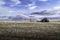 Eight wheel tractor pulling a plow across a tilled field