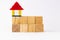 Eight wooden blocks in two rows above each other and a lego house on top for bank loan concept