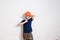 Eight-year-old boy blows a protective orange helmet over his head on a white background