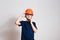 Eight-year-old boy blows a protective orange helmet over his head on a white background