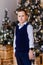 Eight year old boy shirt and vest on Christmas tree background