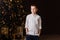 Eight-year-old boy in white shirt stands in Christmas room