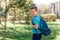 Eight-year-old Caucasian sports boy with a backpack on his back is looking at the camera